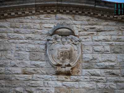 A chiudere la parte sommitale sono lo scudo in pietra con sopra un inno al crocifisso...